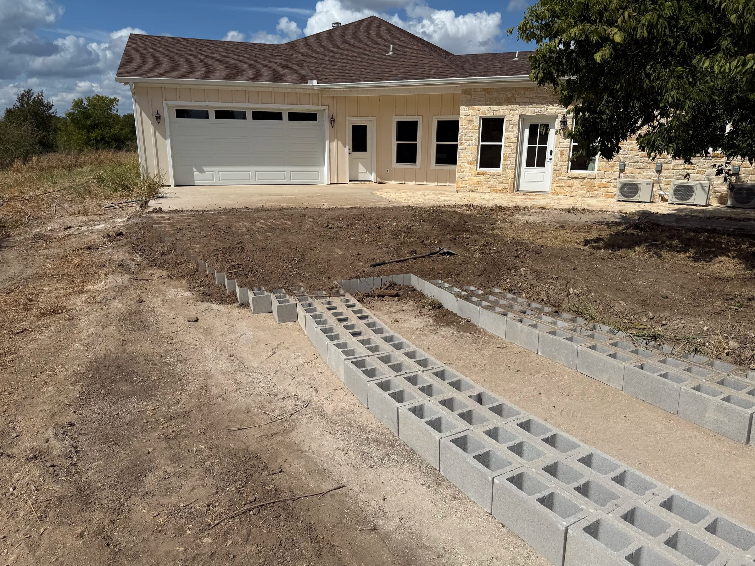 Open-cell concrete driveway blocks leading toward the garage during installation at White Hall
