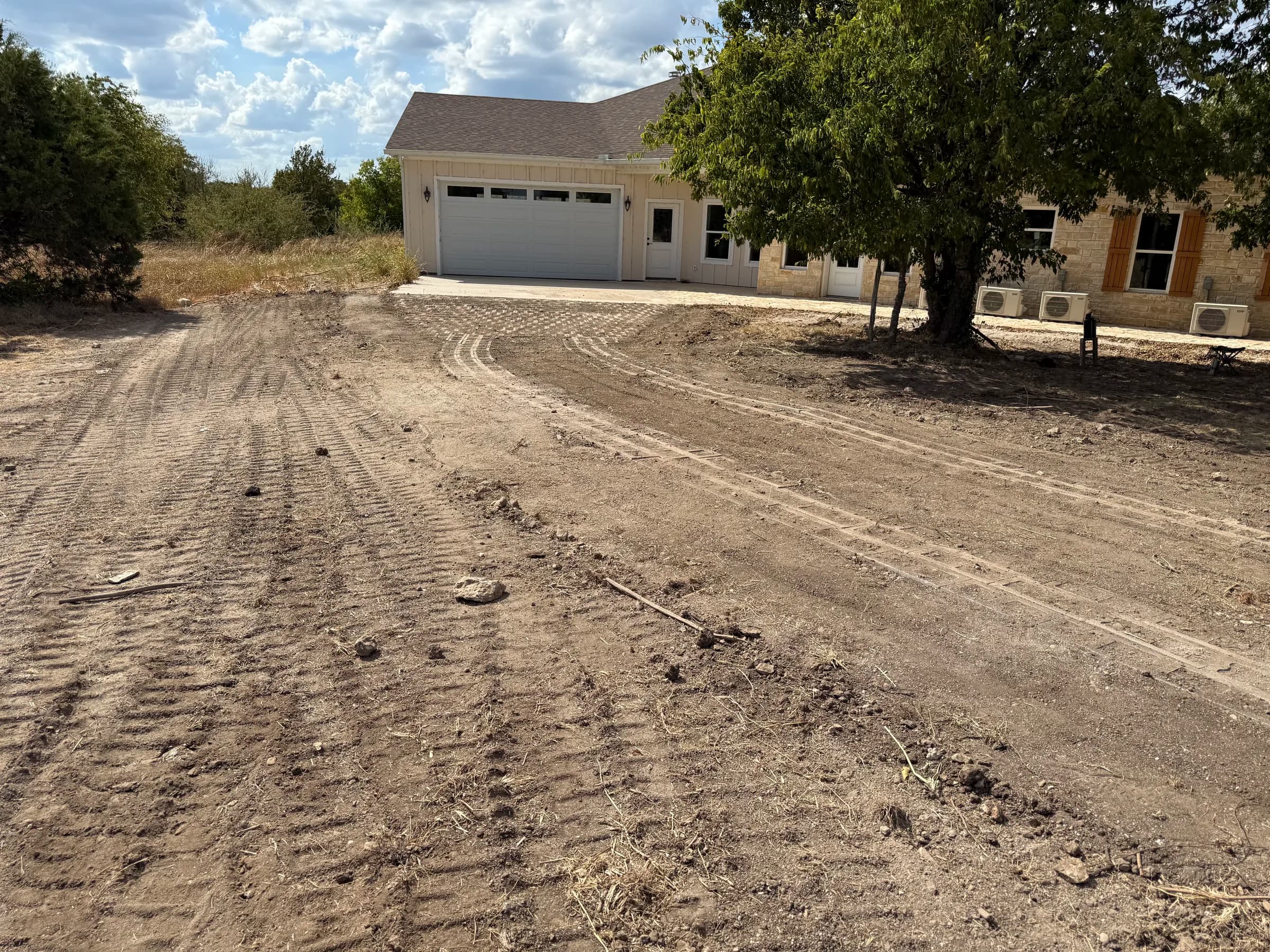 Installed curved concrete driveway strips leading to the White Hall garage before grass establishment
