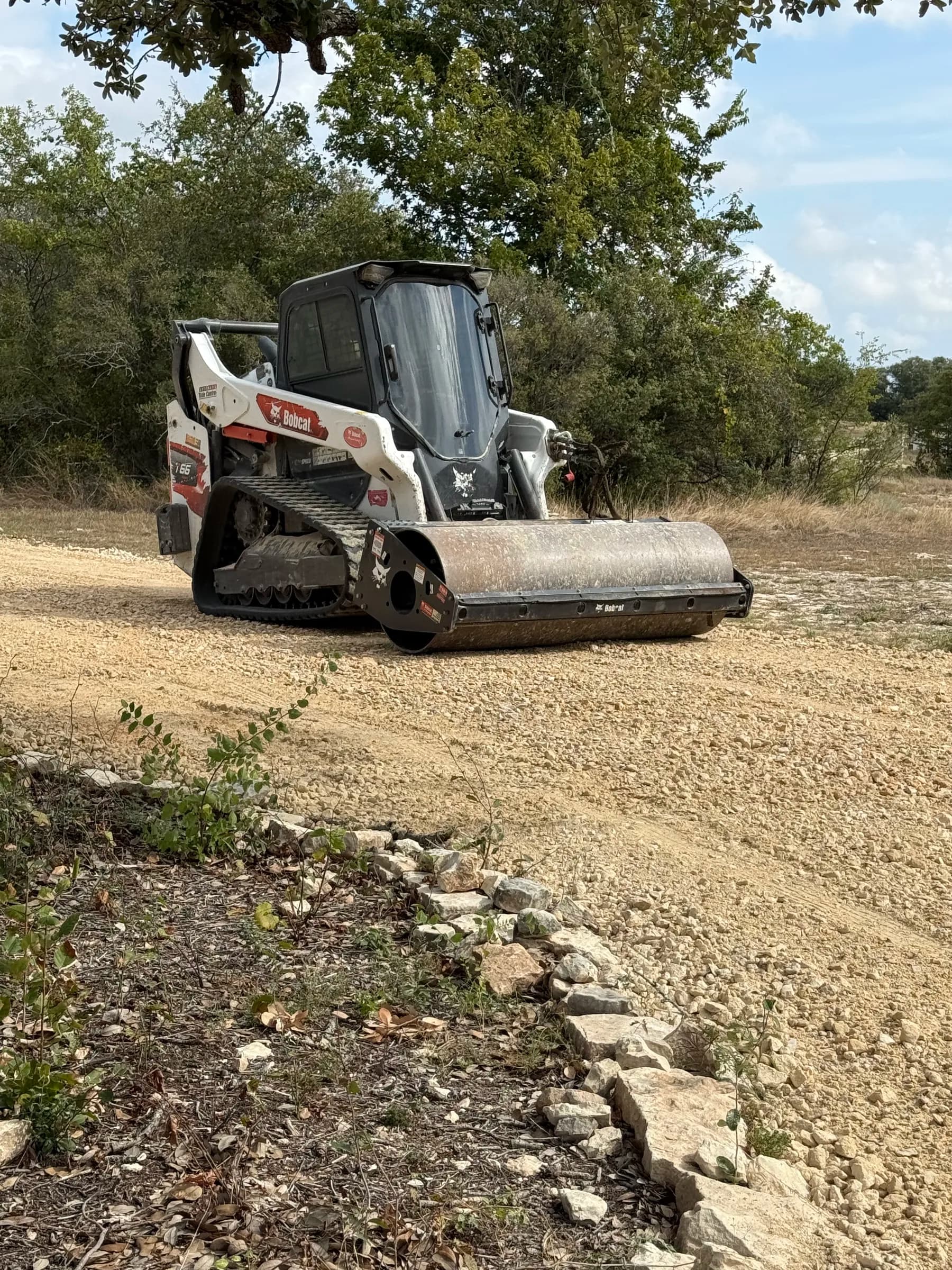 Skid steer grading aggregate at the Ding Dong project