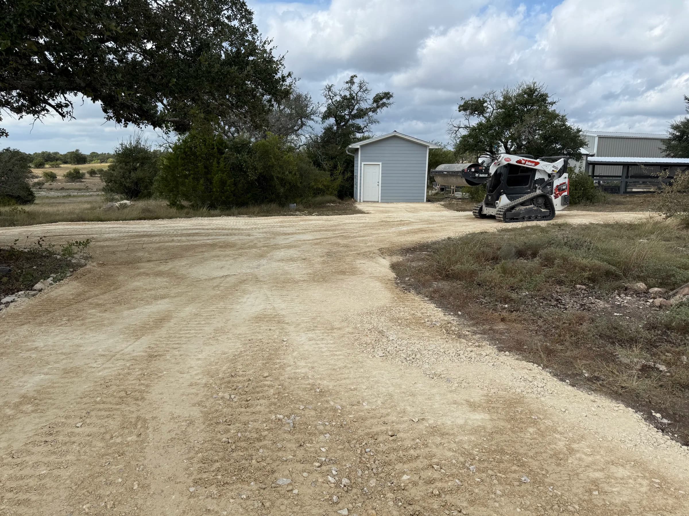 Graded aggregate driveway beside a detached garage at the Ding Dong project
